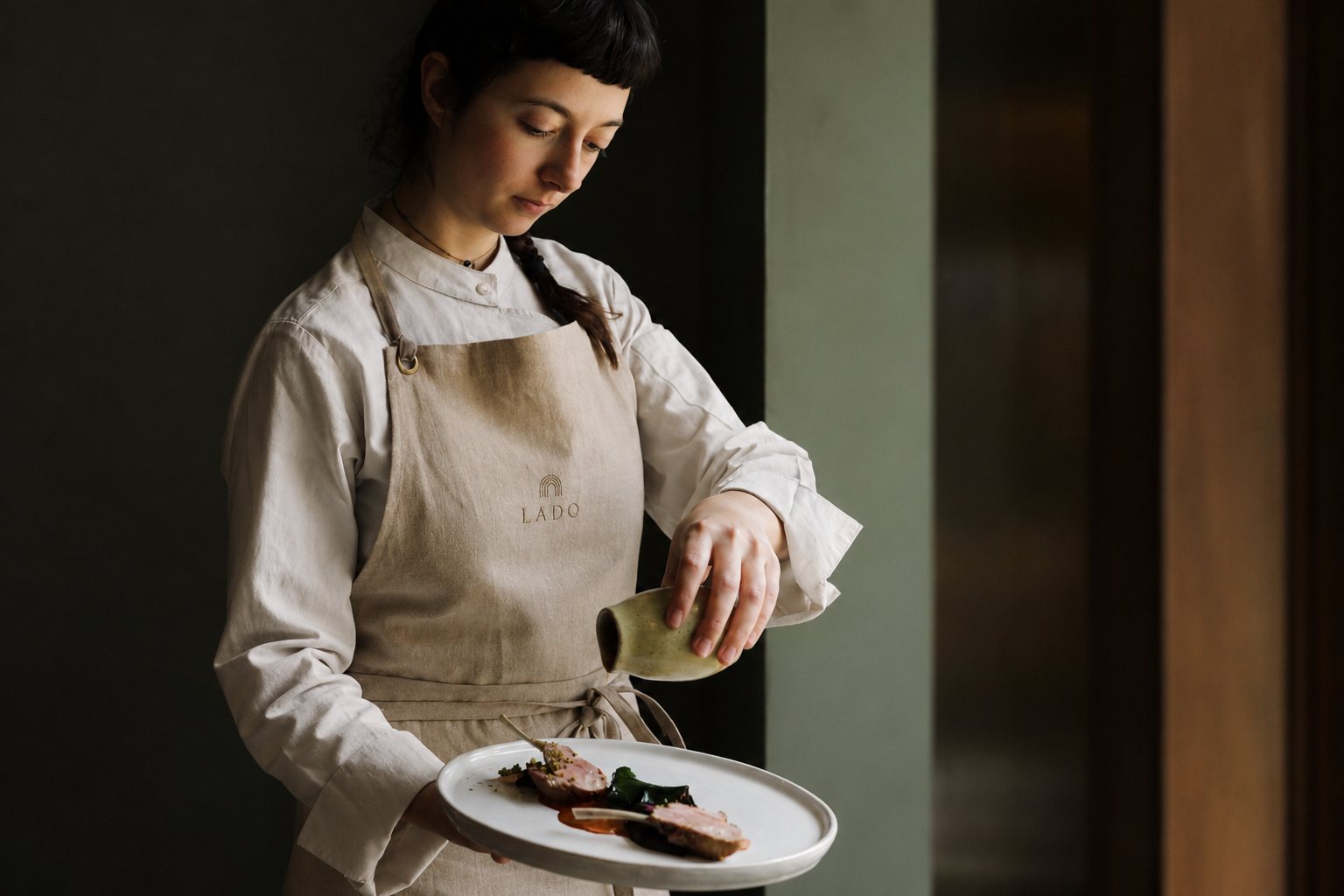 Chef finishing a Lado dish with careful attention to detail