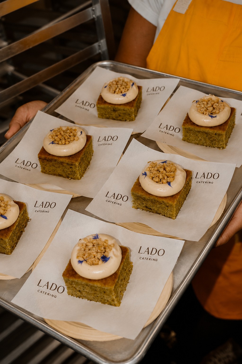 Server carrying a tray of Lado-branded dessert bites