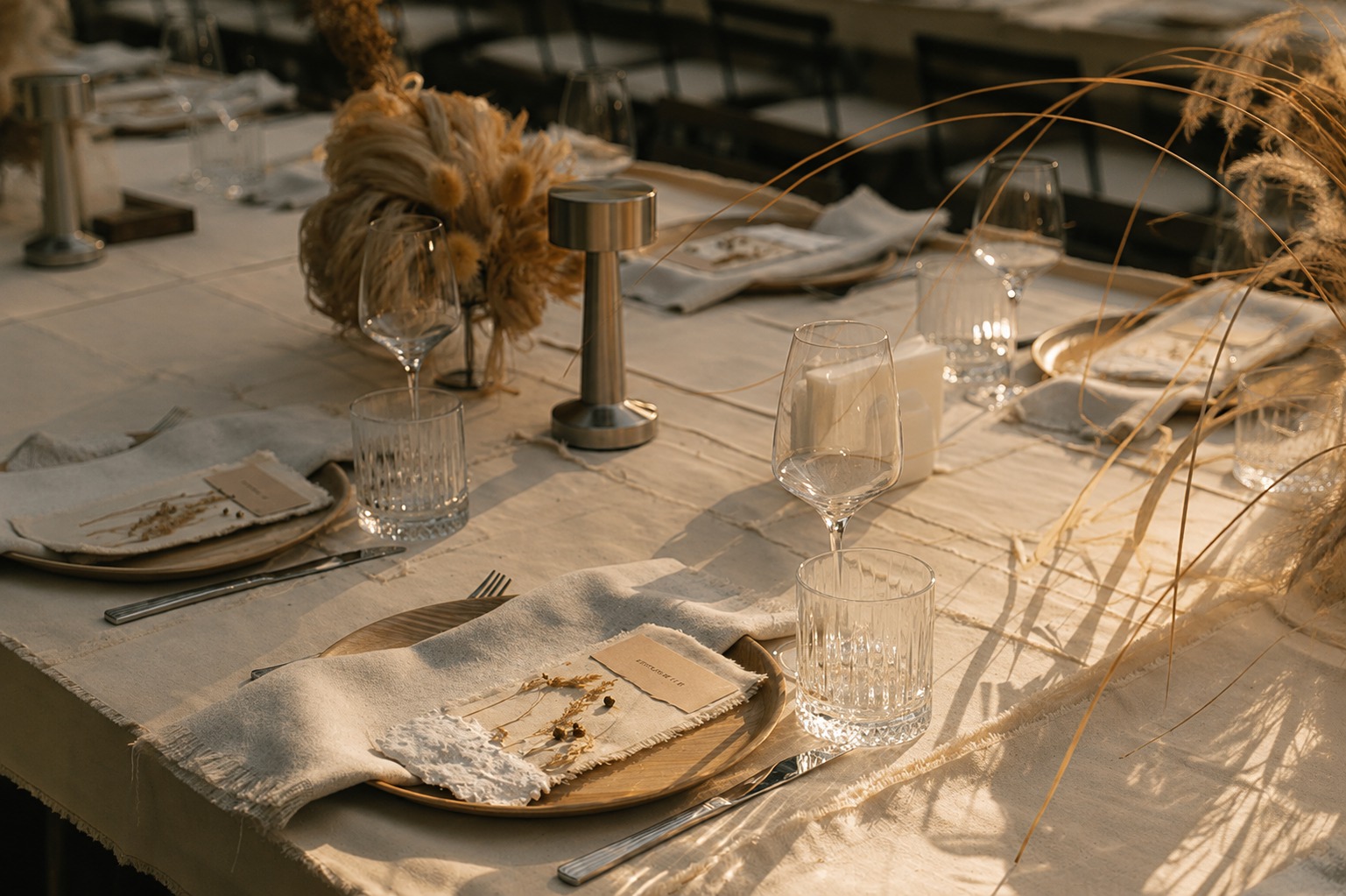 Outdoor wedding table setting styled with dried florals and candlelight