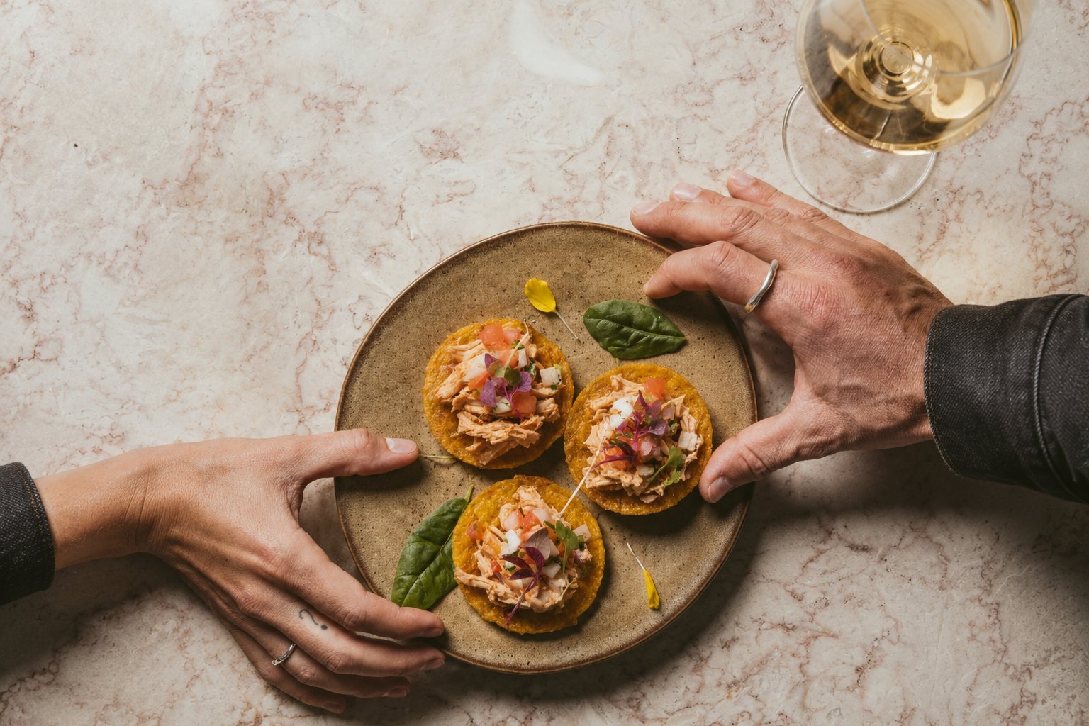 Hands finishing a plate of Lado hors d'oeuvres with care