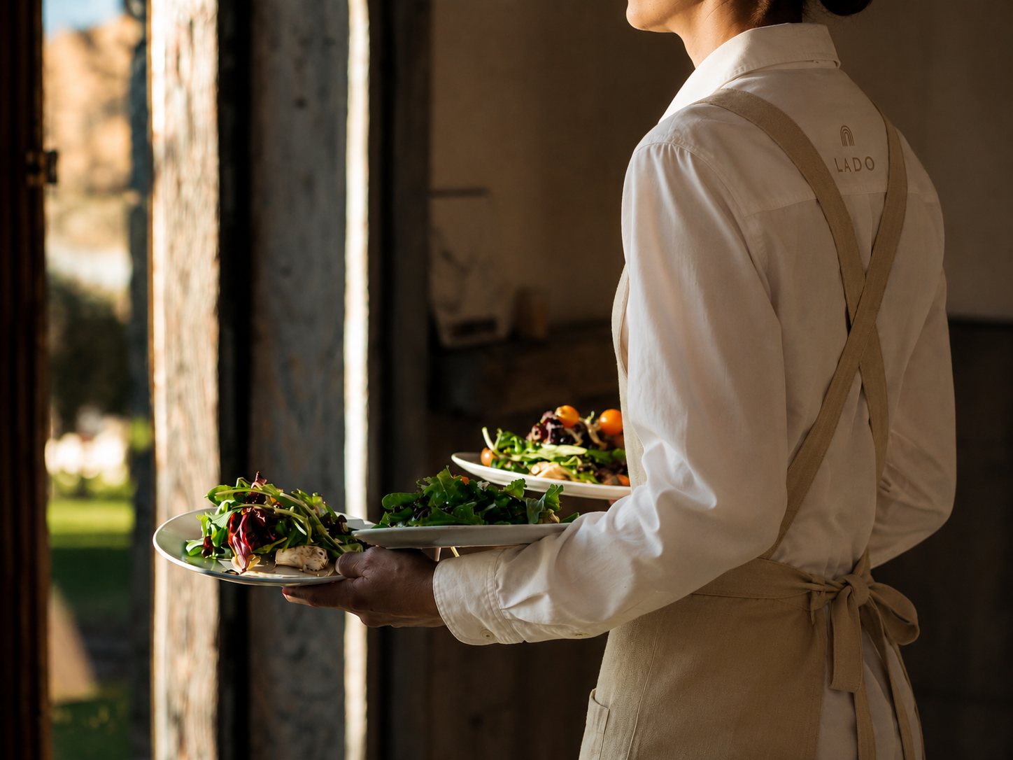 Server carrying a plate through an outdoor archway