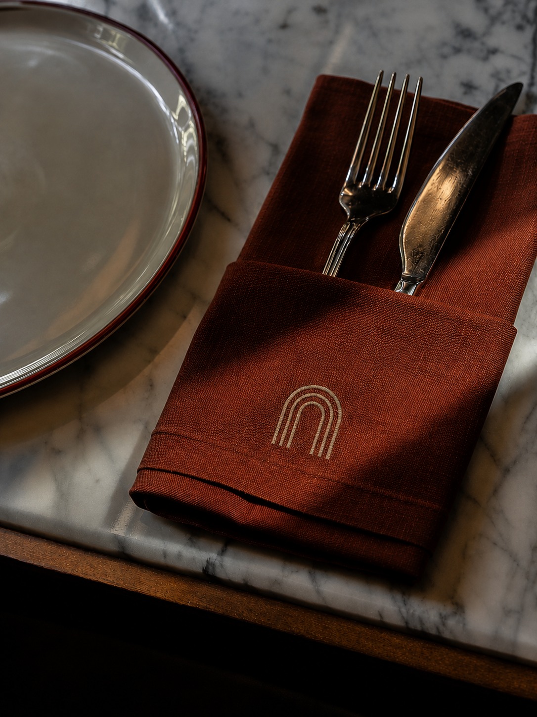 Table setting detail with embroidered linen napkin